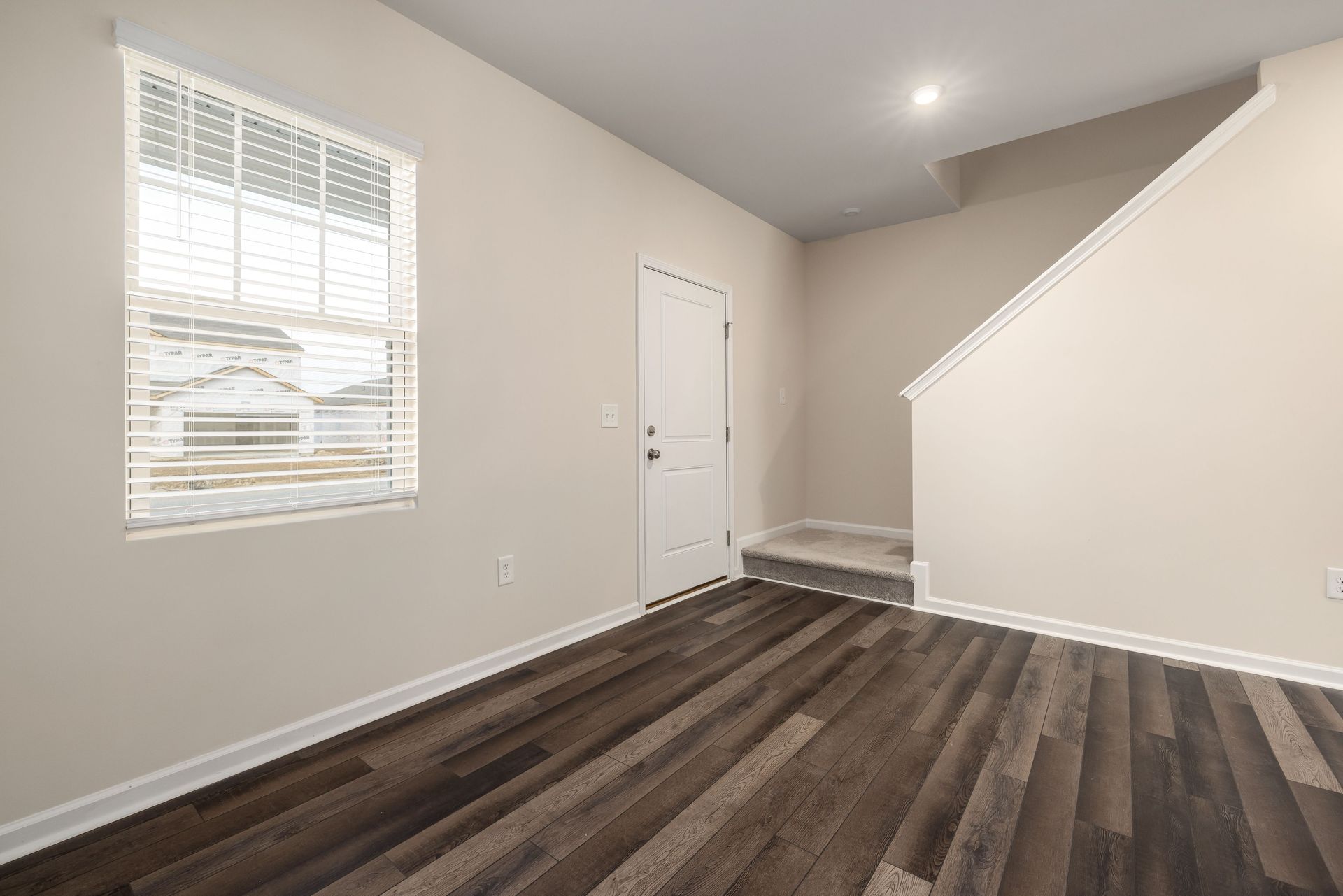 A bright, minimalist home interior showcasing wooden floors and natural light.