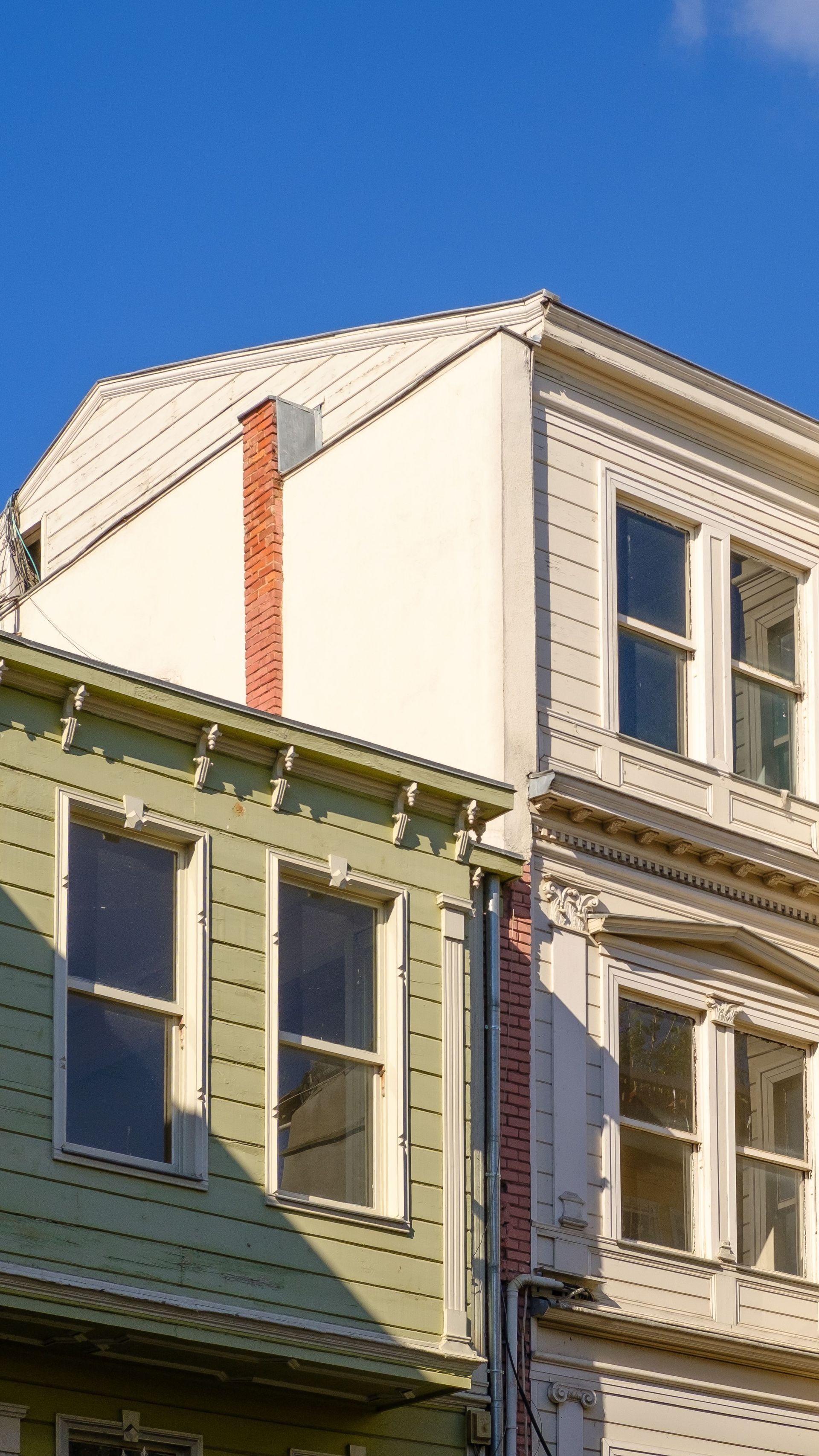 A vibrant historic building facade with contrasting colors against a clear blue sky.