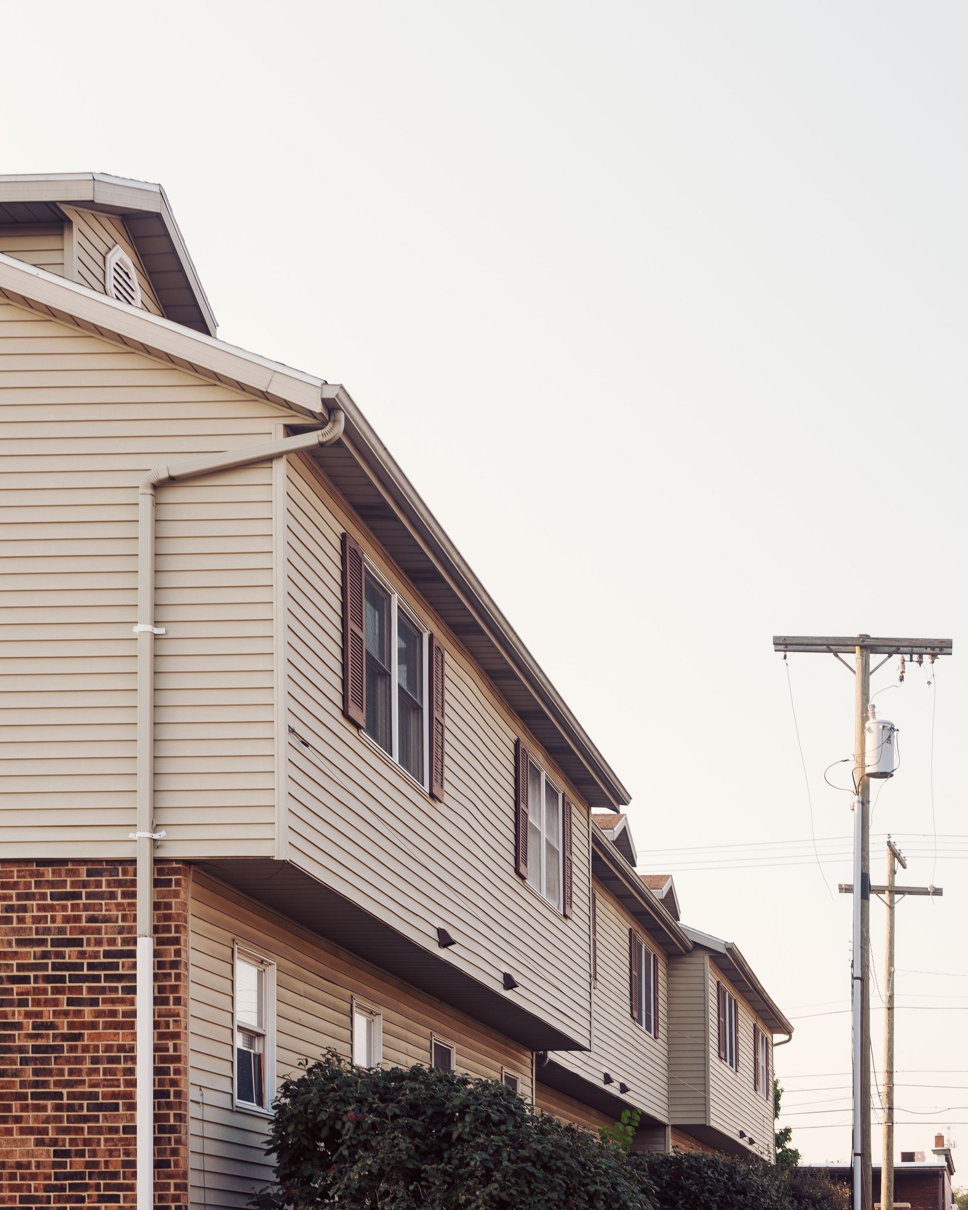 Contemporary suburban row houses with brick and siding exterior in a quiet residential area.